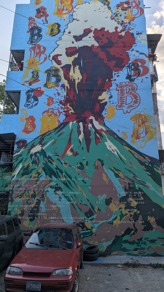 Volcano mural painted across a building wall in Zacamil