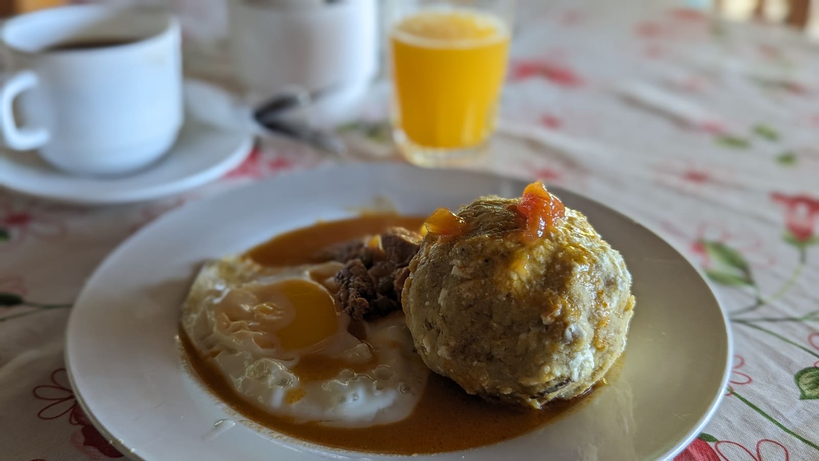 Bolón with fried egg and juice, a typical Ecuadorian breakfast
