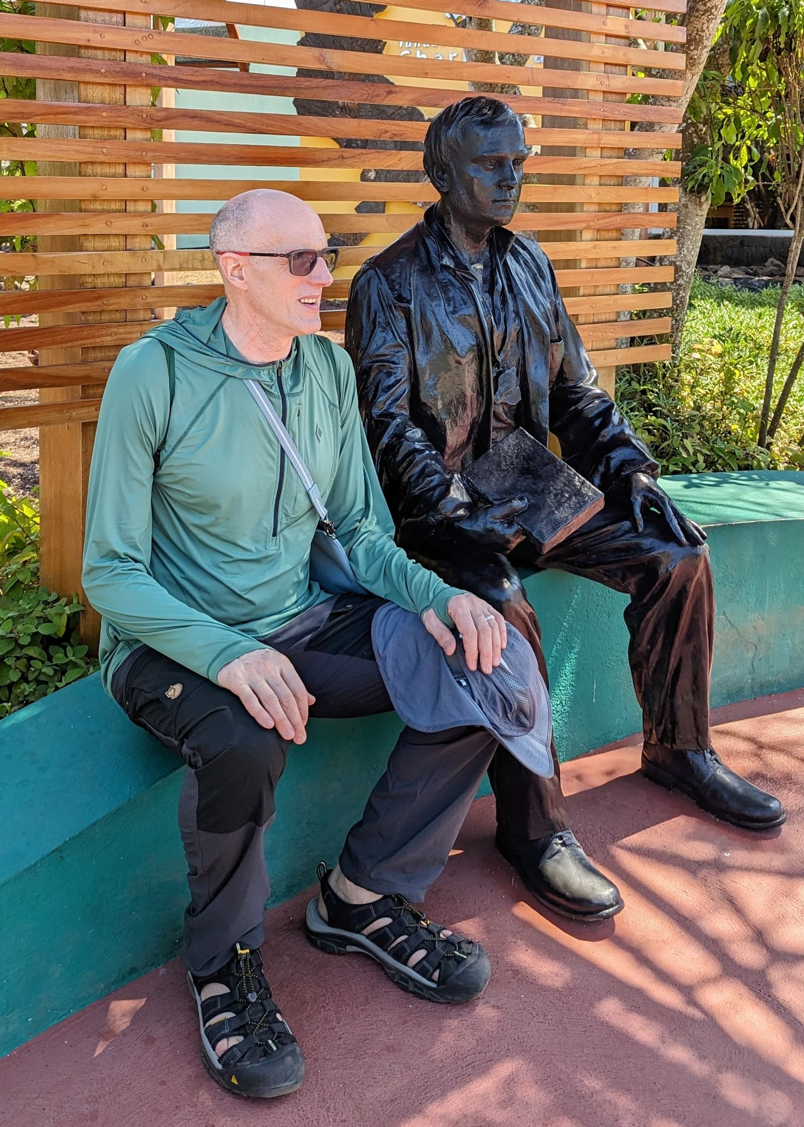 Traveler sitting beside the bronze Charles Darwin statue