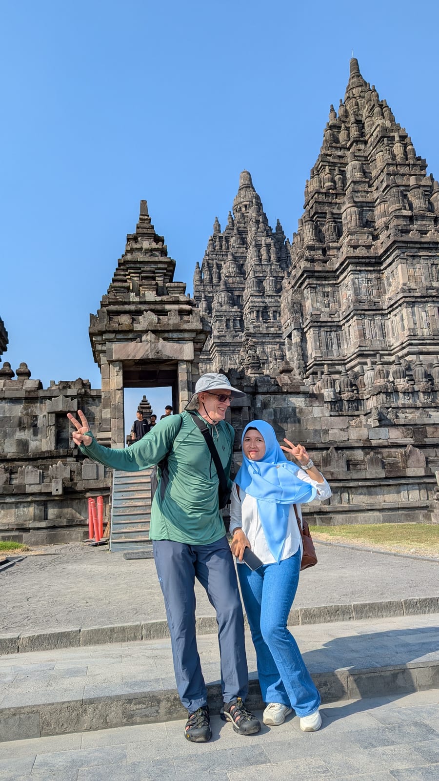 A traveler taking a selfie with a local Indonesian visitor at Prambanan