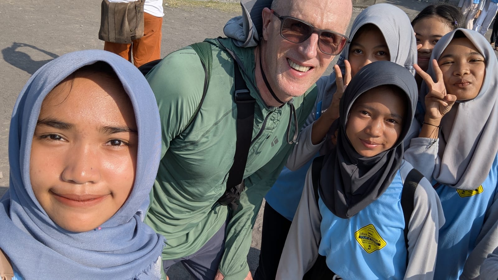 A traveler posing for a selfie with a group of Indonesian schoolgirls at Prambanan