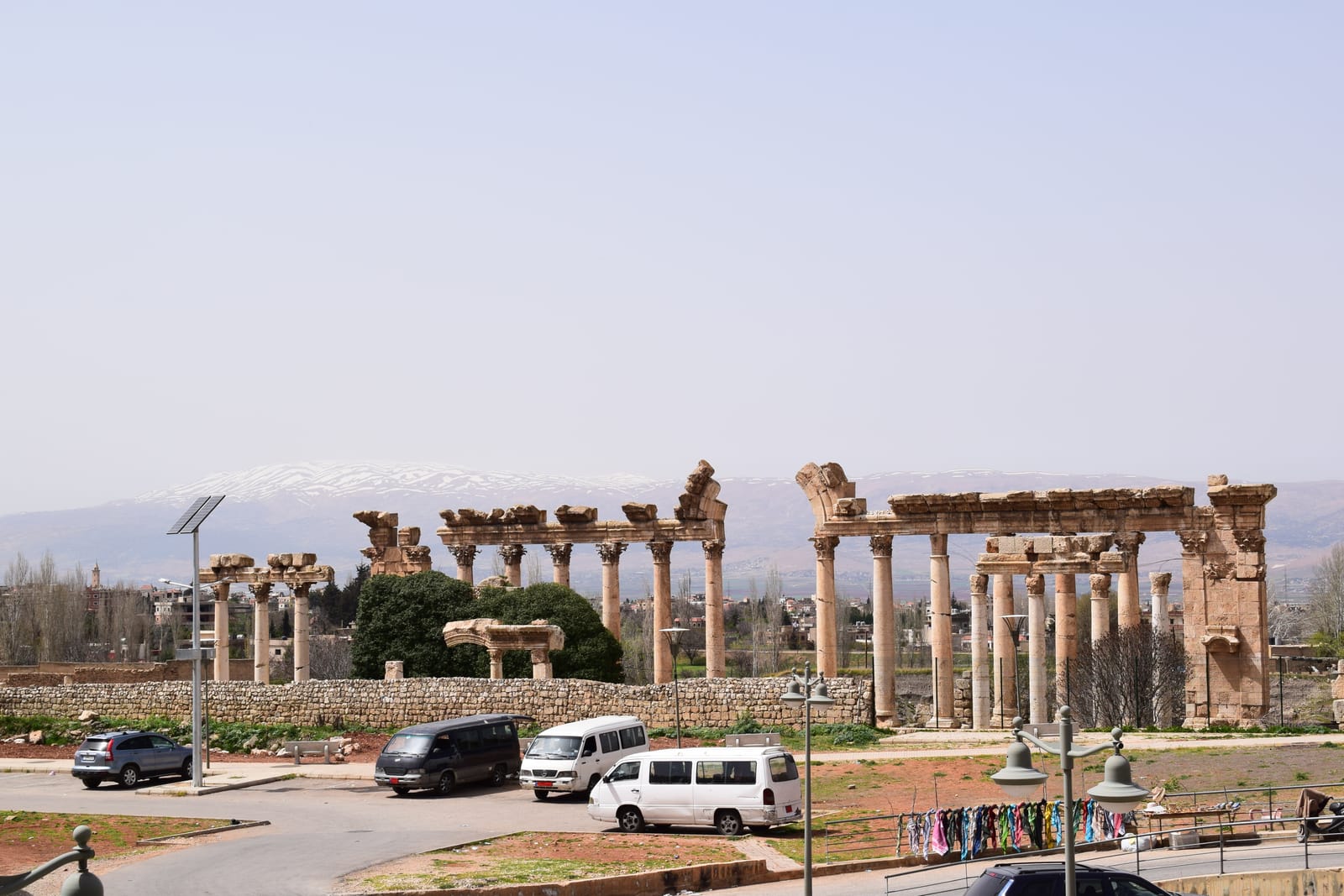 The massive Roman columns of Baalbek with snow-capped mountains behind