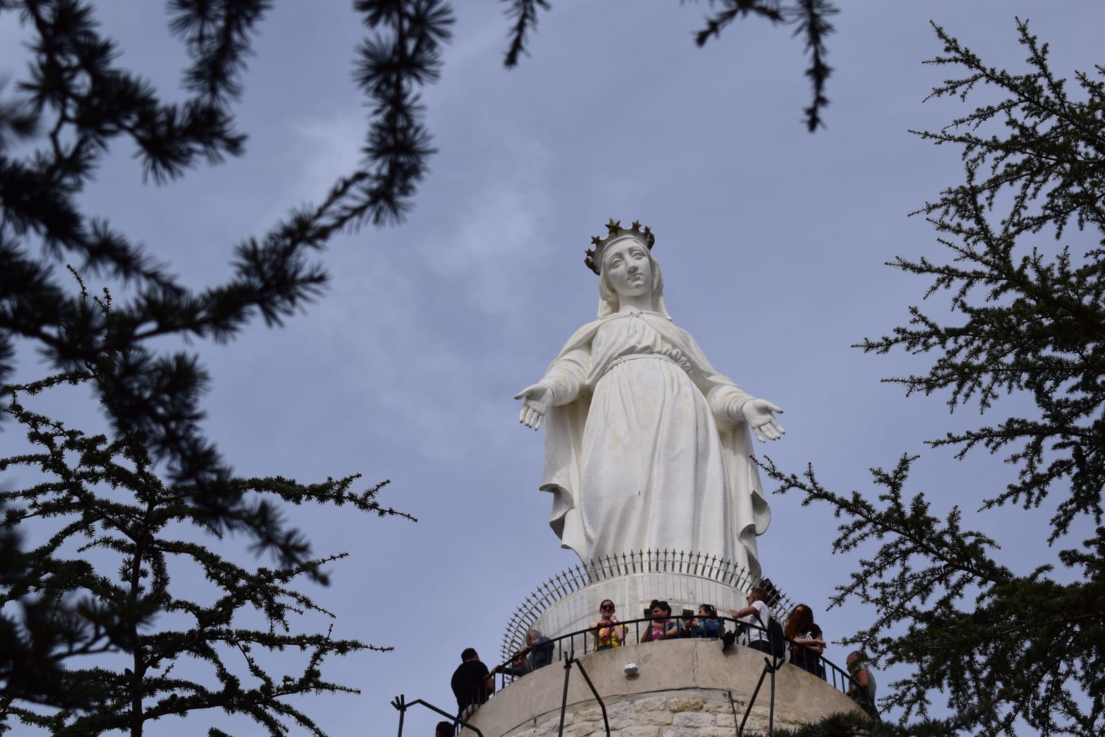 The white statue of Our Lady of Lebanon at Harissa framed by pine branches