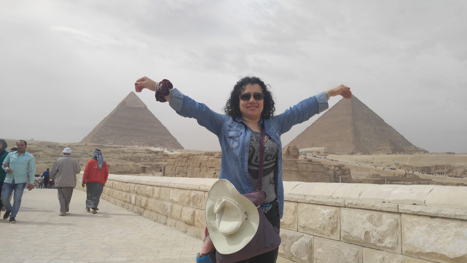 Traveler with arms raised in front of the Great Pyramid