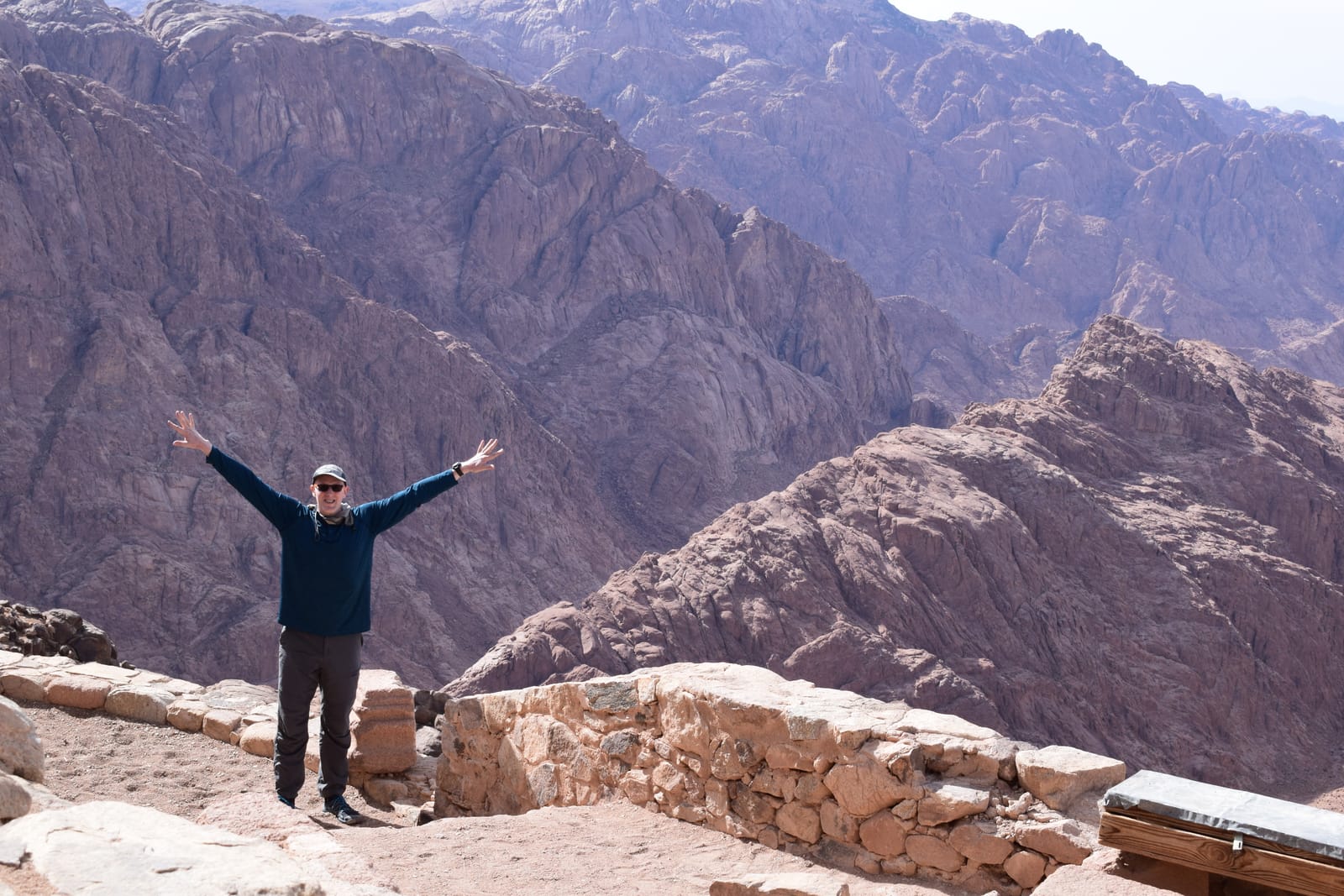 Traveler with arms raised on the summit of Mount Sinai