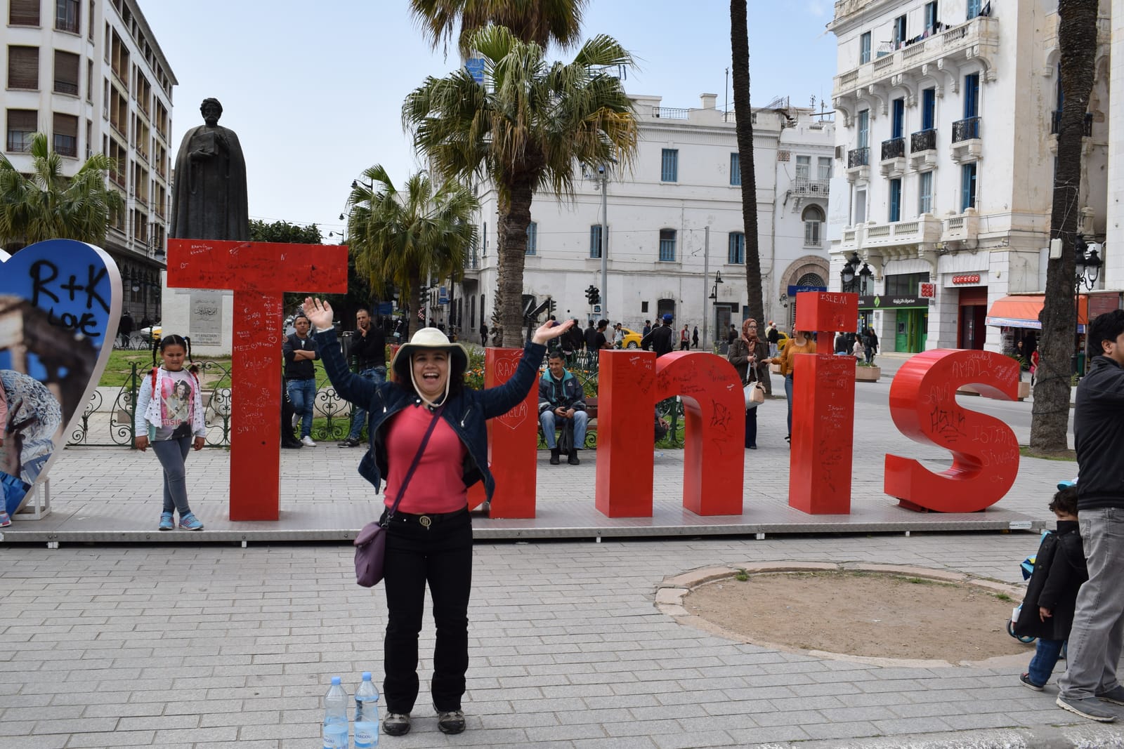 Traveler posing beside a large red TUNIS sign