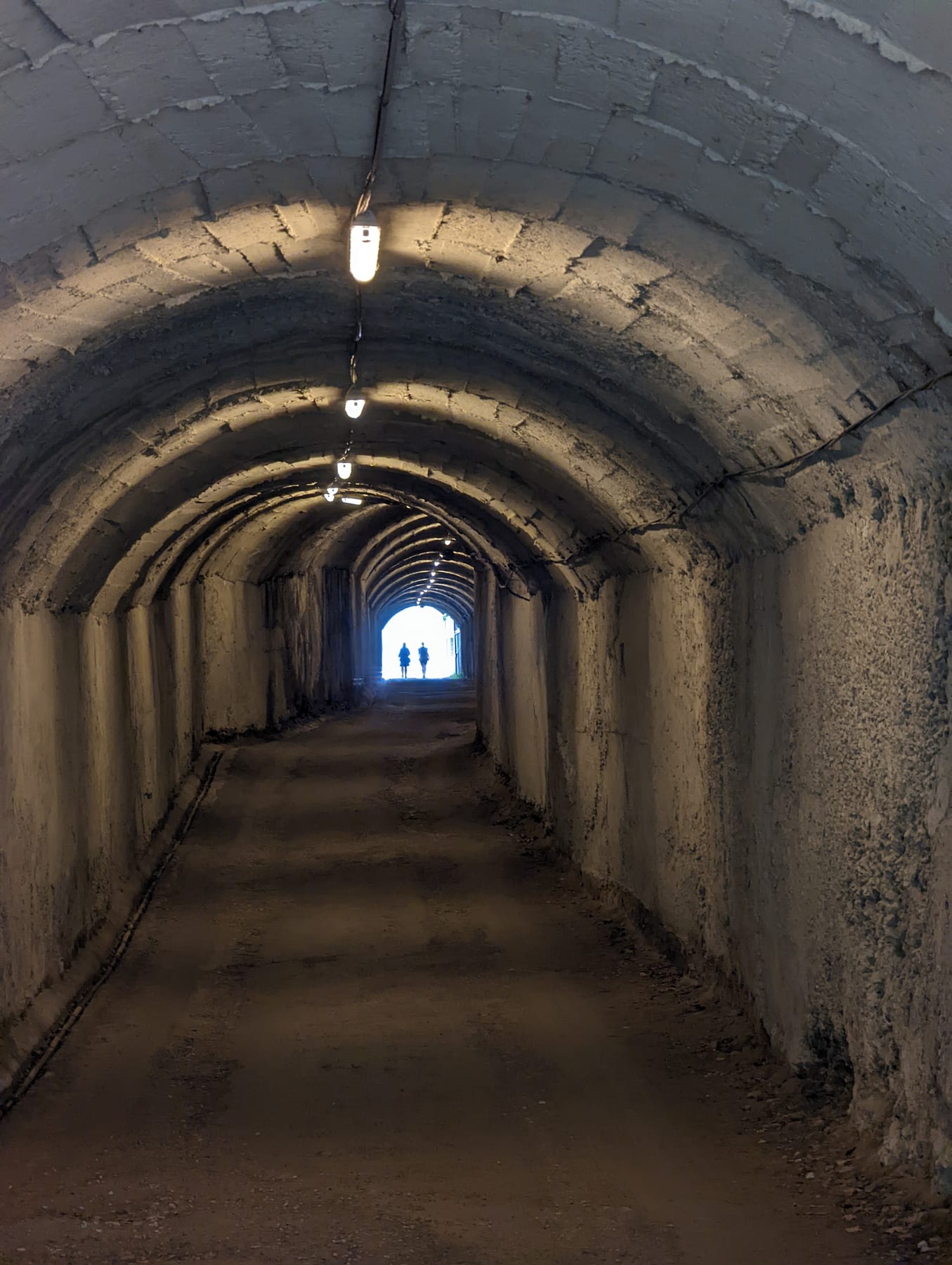 A long curved concrete tunnel inside the Bunk Art museum in Tirana
