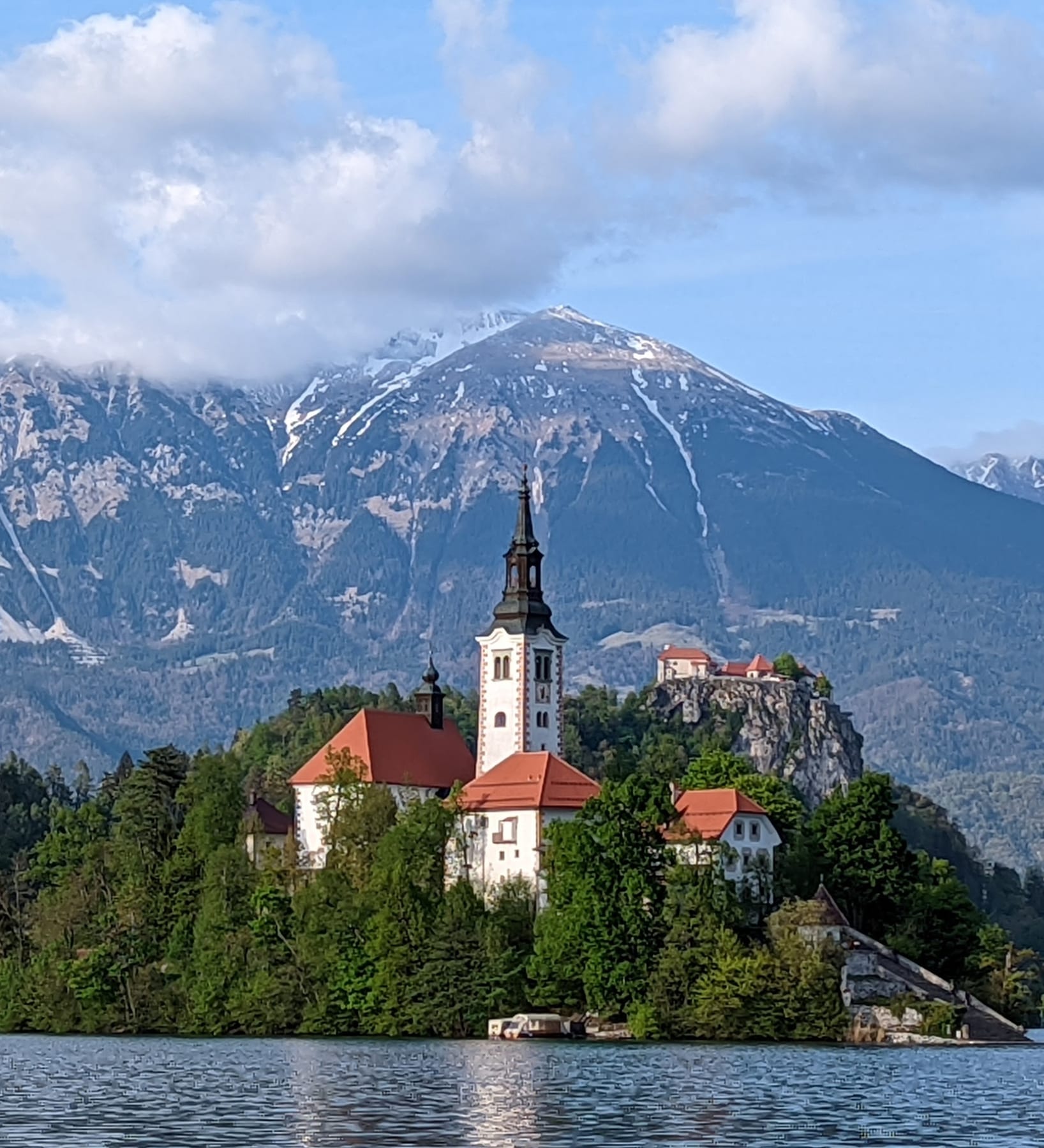 Lake Bled island church and castle in evening light across the water